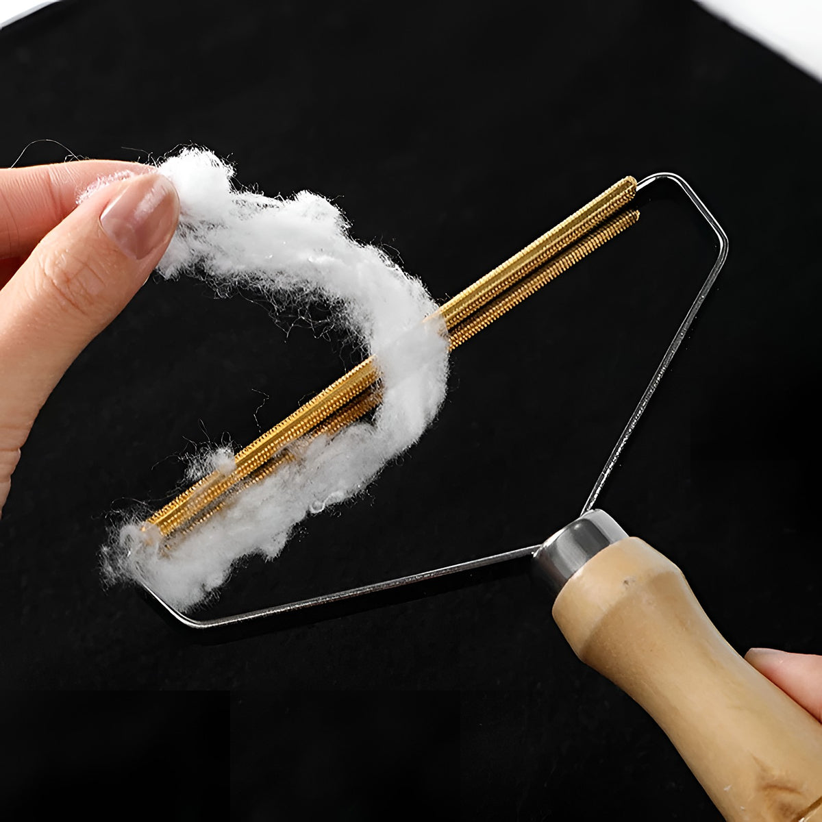 Main qui retire un paquet de peluches de la lame de la brosse en bois