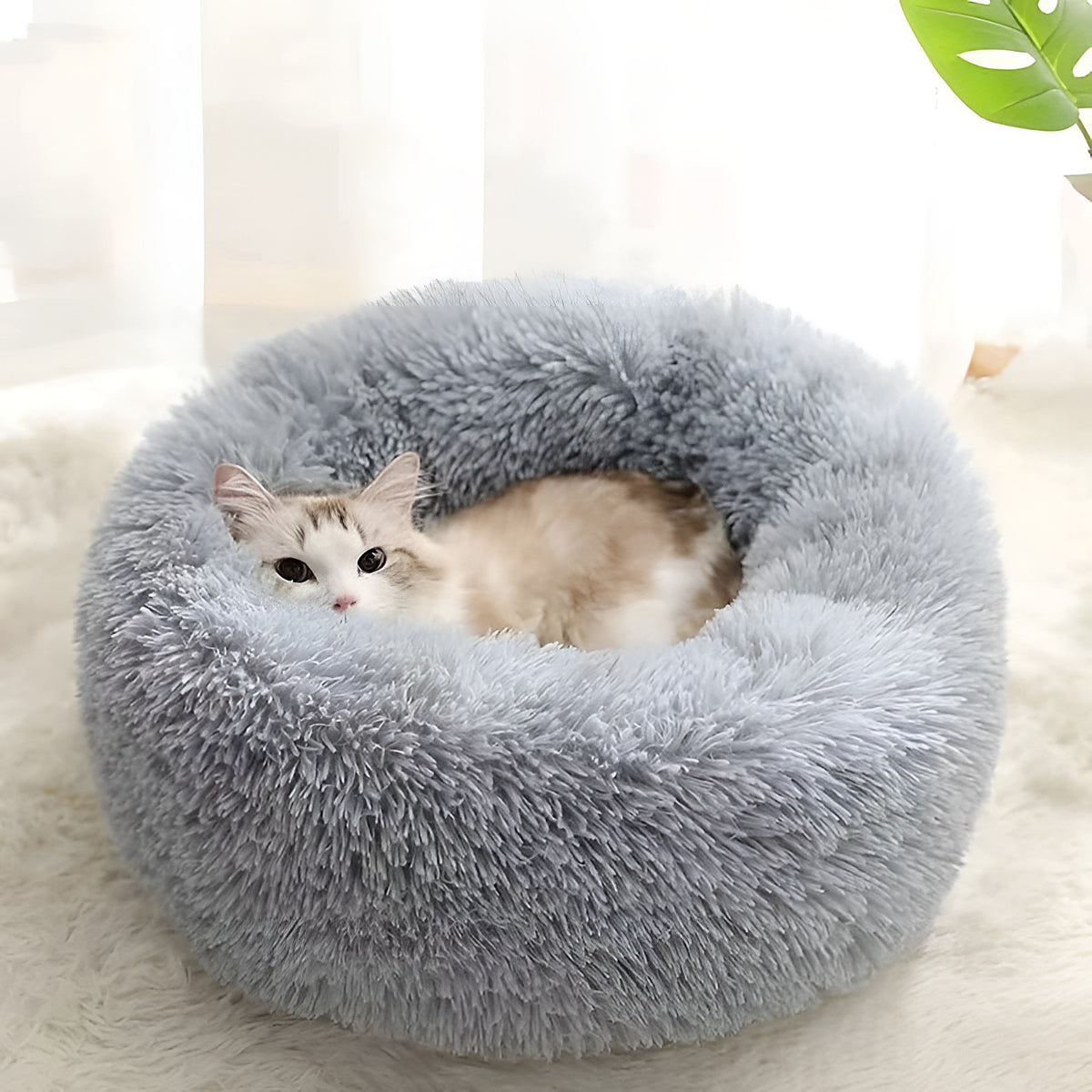 Panier rond en peluche gris clair avec un chat