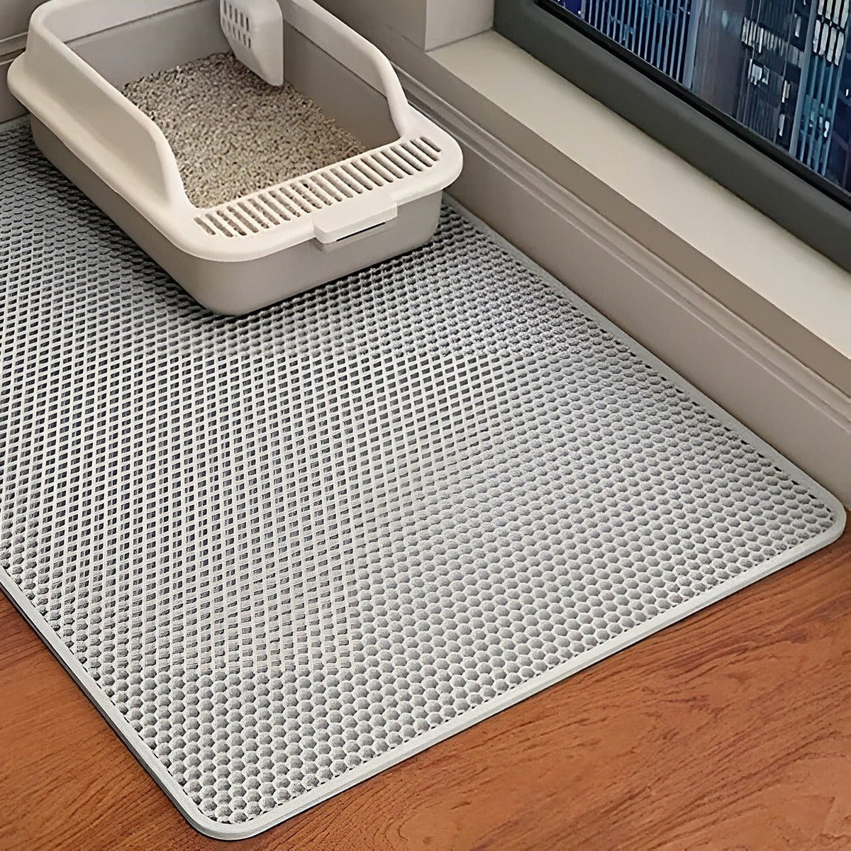 Tapis de litière gris devant un bac à litière